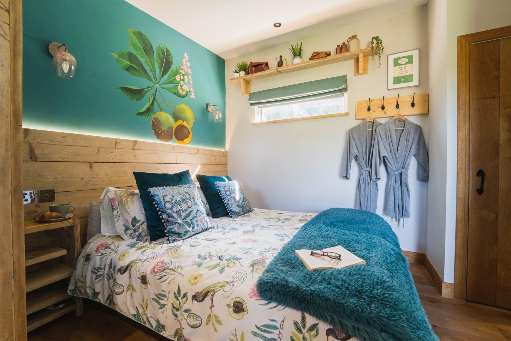 The Roost Glamping Nook bed with book & glasses landscape